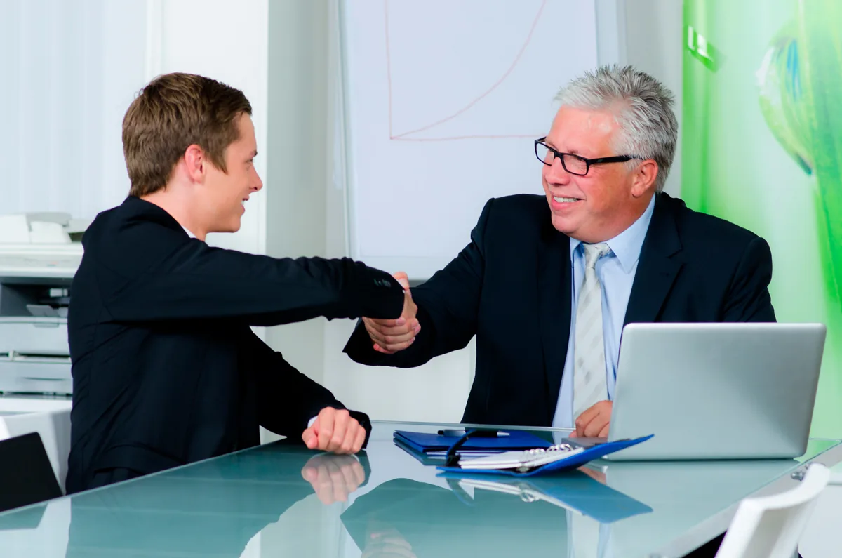 Equipo comercial cerrando un acuerdo B2B con análisis de resultados sobre la mesa